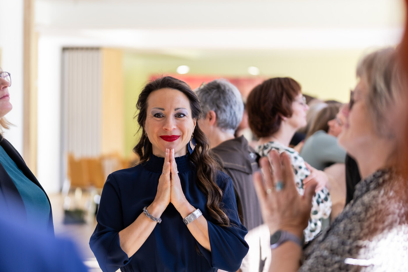 Maria Neuhuber mit gefalteten Händen inmitten der Teilnehmerinnen beim Live-Retreat